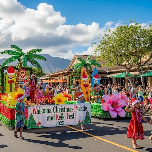 A festive parade on a sunny street with colorful floats, tropical palm props, dancers in bright skirts, and a banner reading “Wailoa Christmas Parade and Keki Fest” amid cheering crowds.
